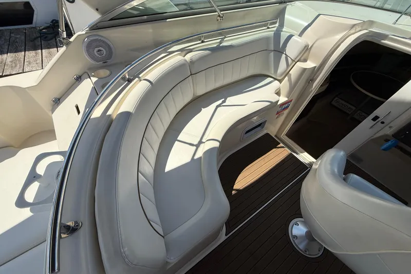Slide: The Image of 2000 Rinker 270 Fiesta Vee boat interior with white seating and wood flooring. - 10