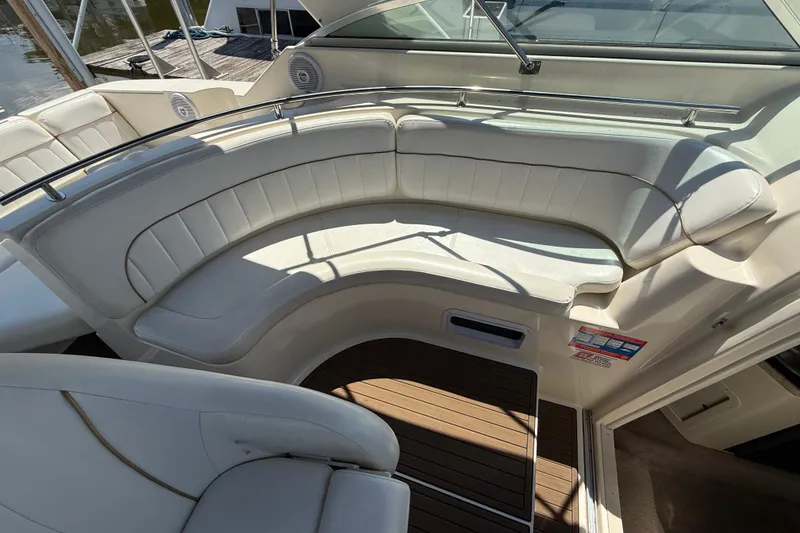 Slide: The Image of 2000 Rinker 270 Fiesta Vee boat interior with white seating and wood flooring. - 11