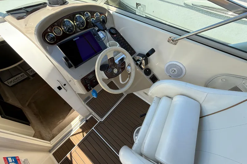 Slide: The Image of Cockpit of 2000 Rinker 270 Fiesta Vee boat with steering wheel and control panel. - 12