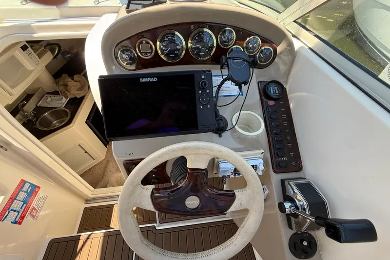 Slide: The Image of Helm of 2000 Rinker 270 Fiesta Vee with steering wheel, gauges, and navigation equipment. - 13