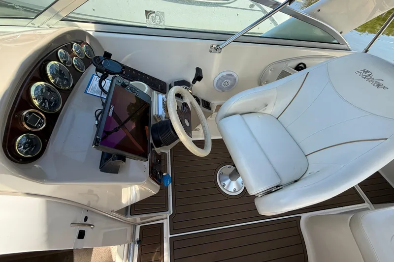 Slide: The Image of Cockpit of 2000 Rinker 270 Fiesta Vee boat with steering wheel and control panel. - 14