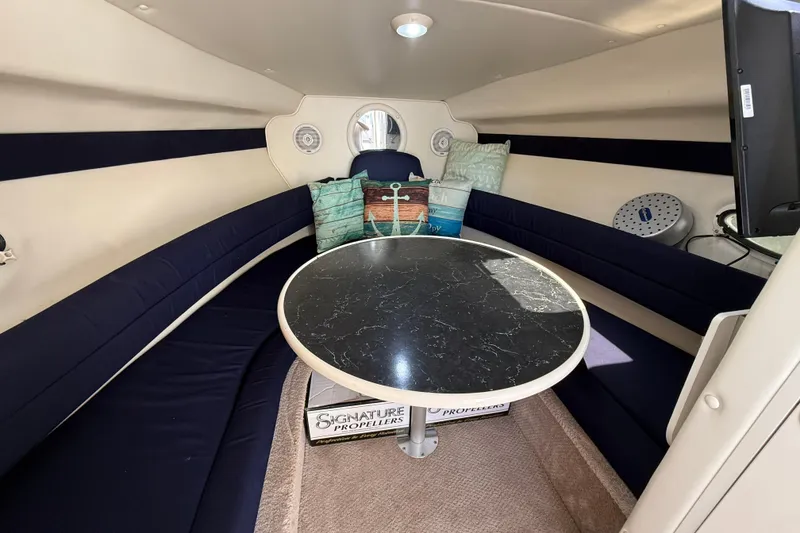 Slide: The Image of Interior of 2000 Rinker 270 Fiesta Vee boat with cozy seating and table. - 15