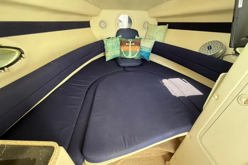 Slide: The Image of Interior of 2000 Rinker 270 Fiesta Vee boat with cozy seating and decorative pillows. - 16