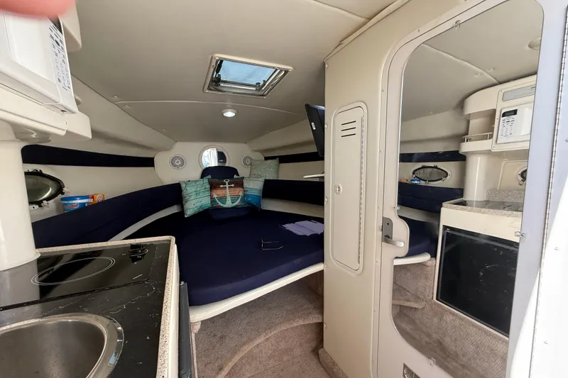 Slide: The Image of Interior of 2000 Rinker 270 Fiesta Vee boat with kitchenette and seating area. - 17