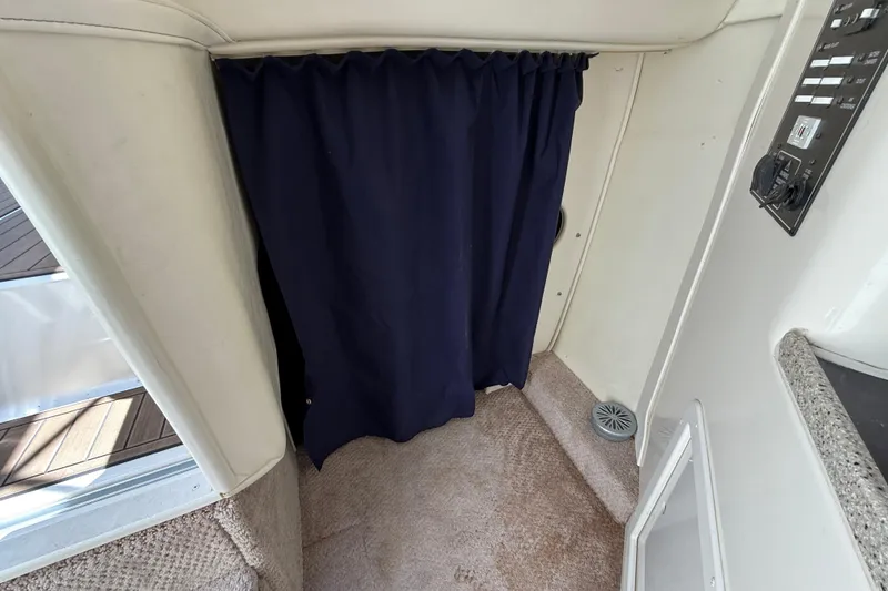 Slide: The Image of Interior of 2000 Rinker 270 Fiesta Vee boat with blue curtain and control panel. - 20