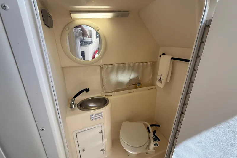 Slide: The Image of Compact bathroom in a 2000 Rinker 270 Fiesta Vee boat with sink and toilet. - 21