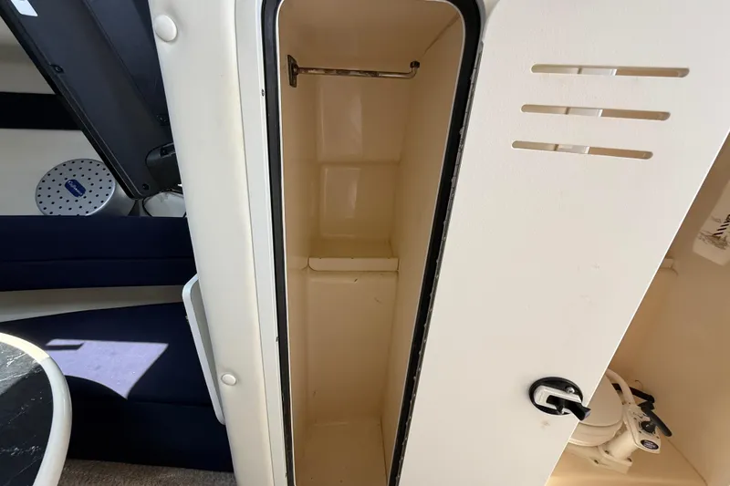 Slide: The Image of Interior of a 2000 Rinker 270 Fiesta Vee boat showing a storage compartment. - 22