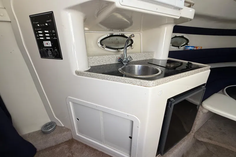 Slide: The Image of 2000 Rinker 270 Fiesta Vee boat interior with kitchenette, sink, and stove. - 24