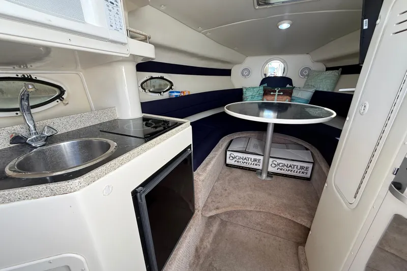 Slide: The Image of Interior of 2000 Rinker 270 Fiesta Vee boat with kitchenette and seating area. - 25