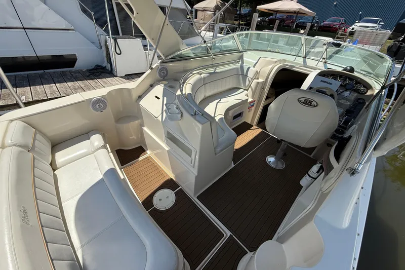 Slide: The Image of 2000 Rinker 270 Fiesta Vee boat interior with white seating and wood flooring. - 6