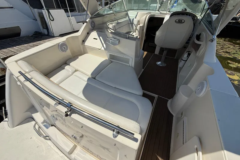 Slide: The Image of Interior of a 2000 Rinker 270 Fiesta Vee boat with white seating and wood flooring. - 7