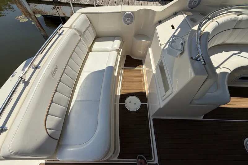 Slide: The Image of Interior of 2000 Rinker 270 Fiesta Vee boat with white seating and wood flooring. - 8