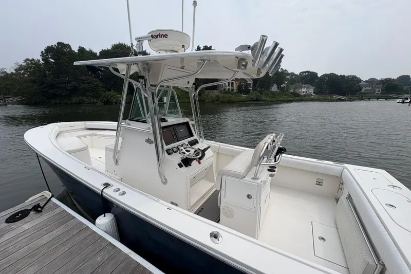 Slide: The Image of 2008 Regulator 26 Forward Seating boat docked by a serene waterfront. - 1