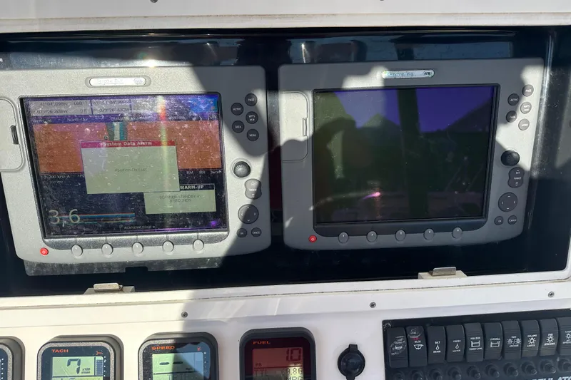 Slide: The Image of 2008 Regulator 26 Forward Seating boat dashboard with dual navigation screens and control panel. - 16