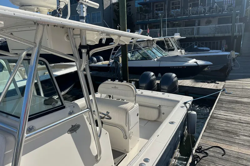 Slide: The Image of 2008 Regulator 26 Forward Seating boat docked at marina with other vessels. - 2