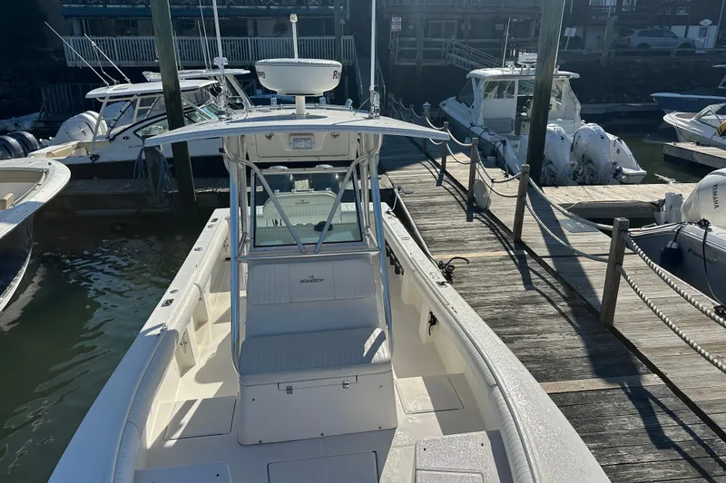 Slide: The Image of 2008 Regulator 26 Forward Seating boat docked at marina, surrounded by other vessels. - 3