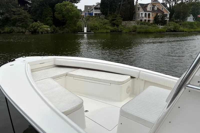 Slide: The Image of 2008 Regulator 26 Forward Seating boat on calm water near a scenic shoreline. - 5