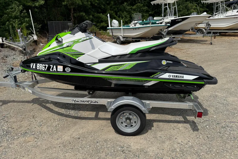 Slide: The Image of 2020 Yamaha WaveRunner EX Deluxe on trailer, green and black design, parked outdoors. - 3