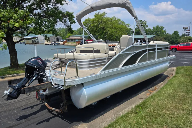 Slide: The Image of 2019 Bennington SX 22 Premium Cruise pontoon boat parked near a scenic lake. - 1