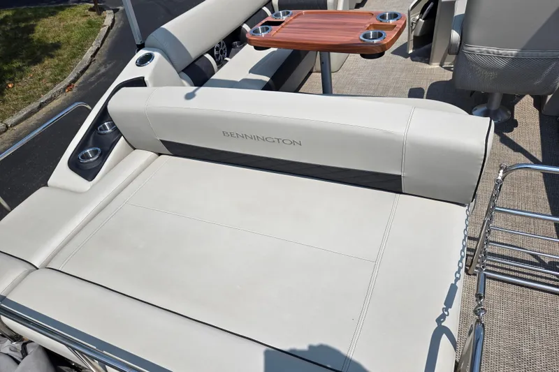 Slide: The Image of 2019 Bennington SX 22 Premium Cruise boat interior with cushioned seating and wooden table. - 16