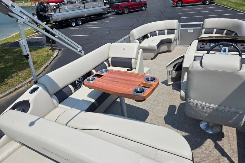 Slide: The Image of 2019 Bennington SX 22 Premium Cruise pontoon boat interior with seating and wooden table. - 17