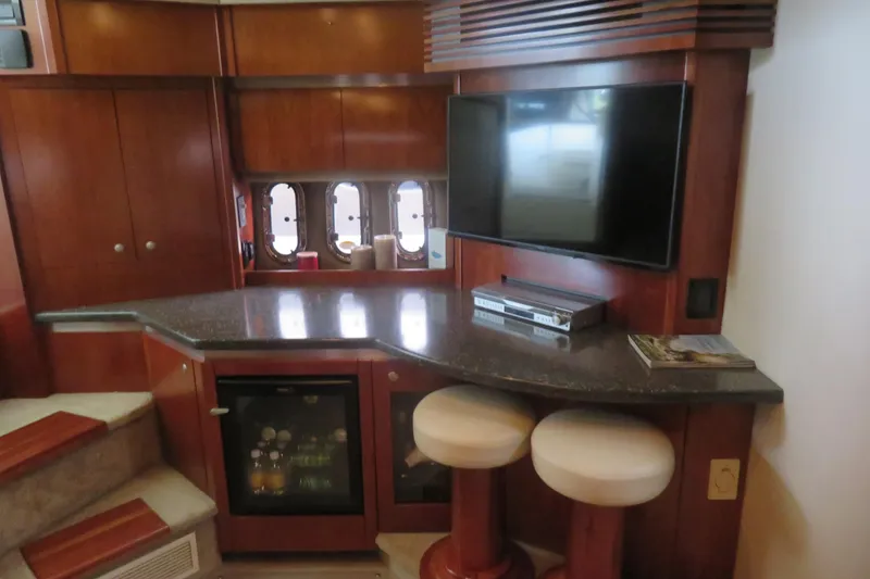 Slide: The Image of Luxurious interior of 2007 Cruisers Yachts 420 Express with TV, bar stools, and mini fridge. - 12