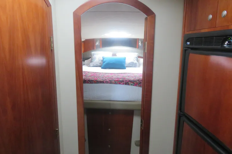 Slide: The Image of Interior cabin view of 2007 Cruisers Yachts 420 Express, featuring a cozy bed setup. - 5