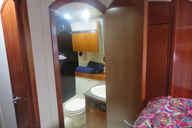 Slide: The Image of 2007 Cruisers Yachts 420 Express interior bathroom with wooden cabinetry and modern fixtures. - 6