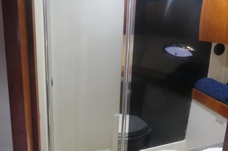 Slide: The Image of 2007 Cruisers Yachts 420 Express bathroom interior with shower and porthole. - 7