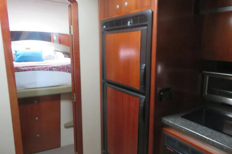 Slide: The Image of 2007 Cruisers Yachts 420 Express interior with kitchen and bedroom view. - 8