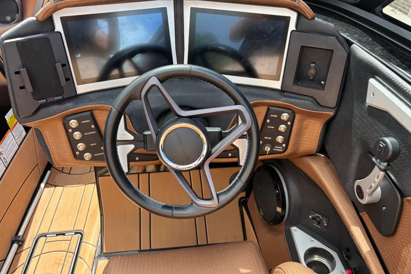 Slide: The Image of 2021 Centurion Ri265 boat dashboard with dual screens and modern steering wheel. - 10