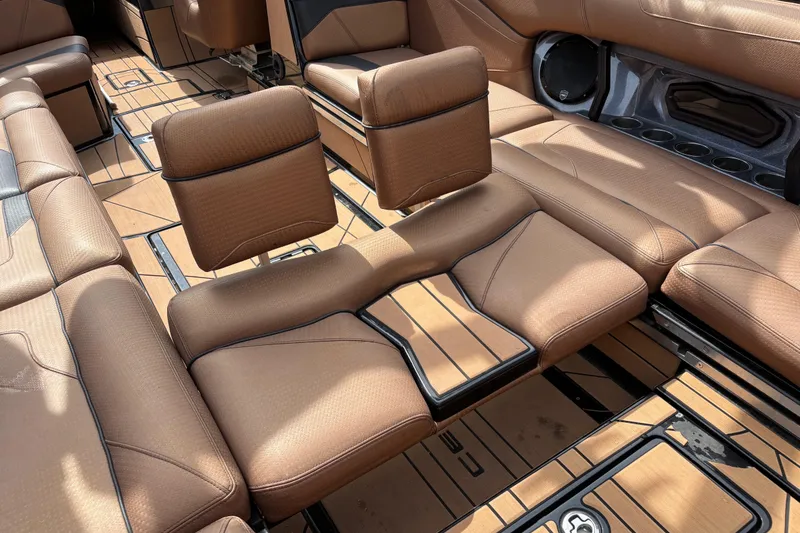 Slide: The Image of 2021 Centurion Ri265 boat interior with brown leather seating and cup holders. - 11