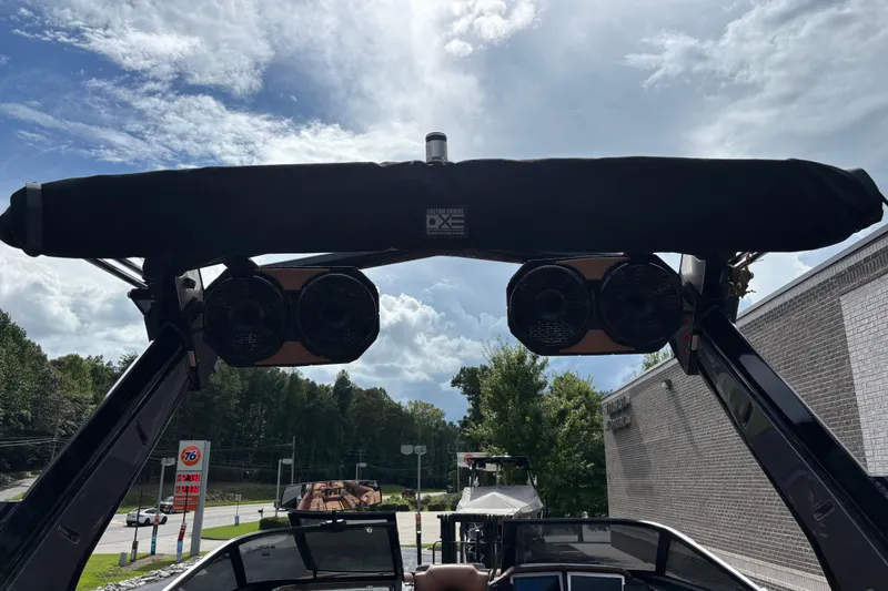 Slide: The Image of 2021 Centurion Ri265 boat with speakers and canopy against a cloudy sky. - 12