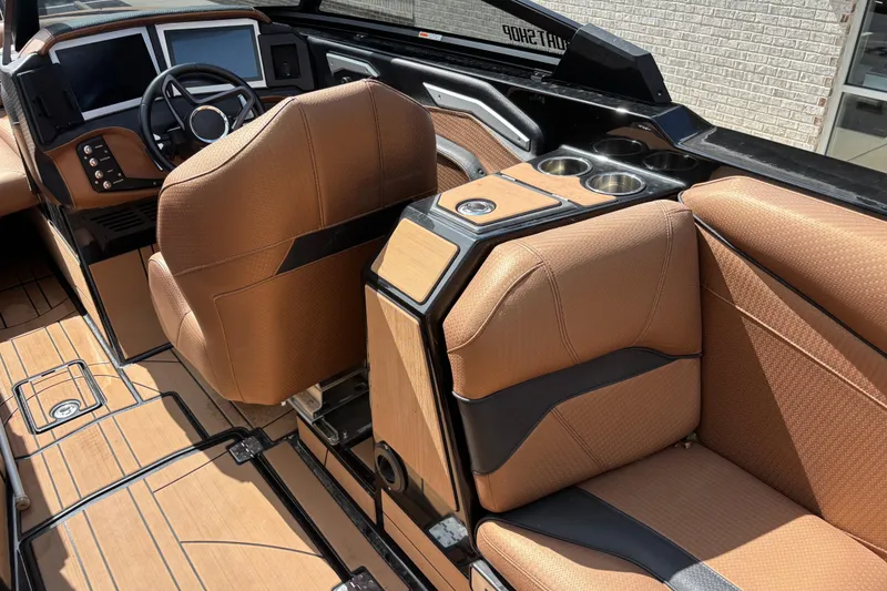 Slide: The Image of 2021 Centurion Ri265 boat interior with brown seating and modern dashboard. - 8