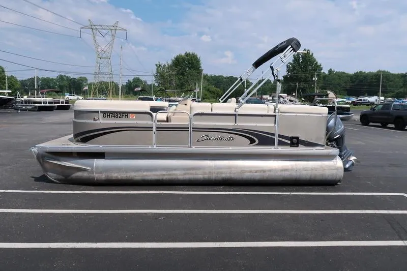 The Image of 2012 Sweetwater 200 Classic pontoon boat parked in a lot under a blue sky. - 0