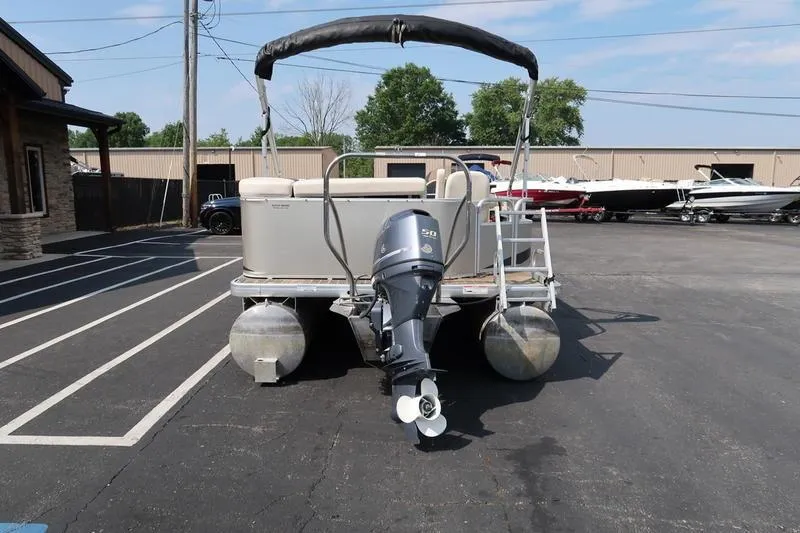 Slide: The Image of 2012 Sweetwater 200 Classic pontoon boat with outboard motor in a parking lot. - 4