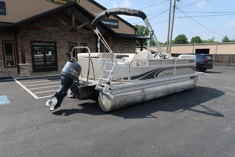 Slide: The Image of 2012 Sweetwater 200 Classic pontoon boat parked outside a marine dealership. - 6