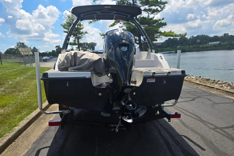 Slide: The Image of 2024 Starcraft SVX 191 OB boat with outboard motor, parked near a scenic waterfront. - 2