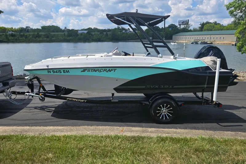 Slide: The Image of 2024 Starcraft SVX 191 OB boat on trailer by a lake under a cloudy sky. - 8