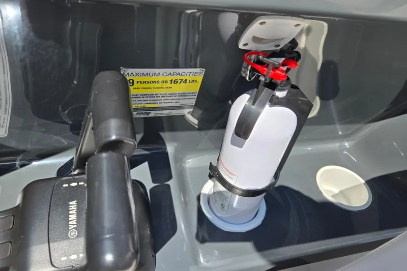 Slide: The Image of 2011 Yamaha AR210 boat interior with fire extinguisher and capacity label. - 13