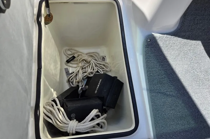 Slide: The Image of Storage compartment in a 2011 Yamaha AR210 boat with ropes and accessories. - 14