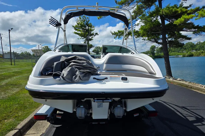 Slide: The Image of 2011 Yamaha Boats AR210 on trailer by a lake, under a clear blue sky. - 2