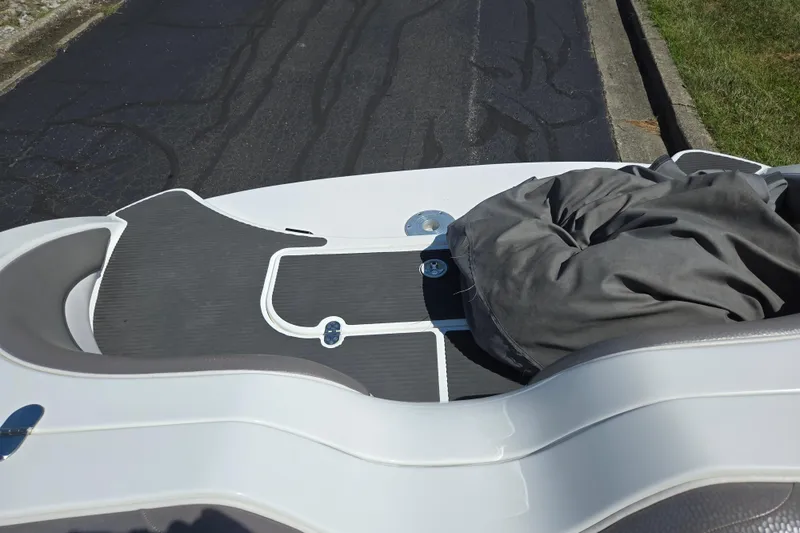 Slide: The Image of 2011 Yamaha Boats AR210 deck with cover, parked on asphalt. - 25