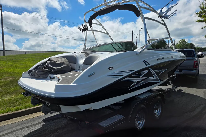 Slide: The Image of 2011 Yamaha Boats AR210 on trailer, parked outdoors under a partly cloudy sky. - 3