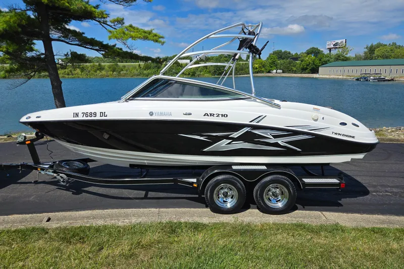 Slide: The Image of 2011 Yamaha AR210 boat on trailer by a lake, under a clear sky. - 9