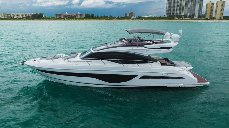 Slide: The Image of Luxury 2022 Princess S66 yacht cruising on turquoise waters near a city skyline. - 21