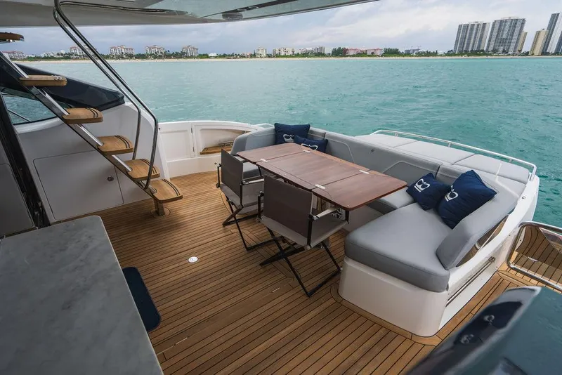 Slide: The Image of Luxurious 2022 Princess S66 yacht deck with seating and dining area, overlooking serene waters. - 34