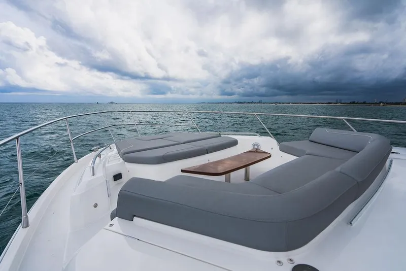 Slide: The Image of Luxurious 2022 Princess S66 yacht deck with gray seating, overlooking a vast ocean under cloudy skies. - 43