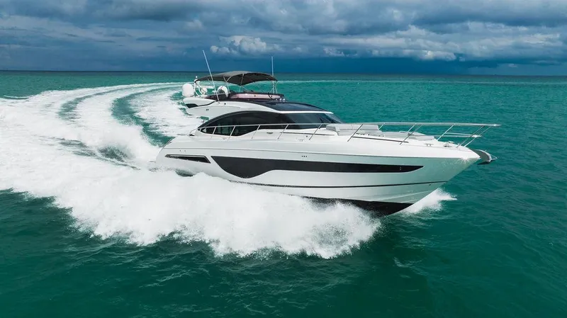 Slide: The Image of Luxury 2022 Princess S66 yacht cruising on turquoise waters under cloudy skies. - 6