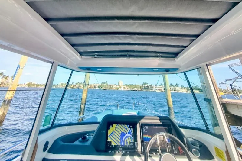Slide: The Image of Interior view of 2021 Axopar 28 CABIN boat with navigation system and water scenery. - 12